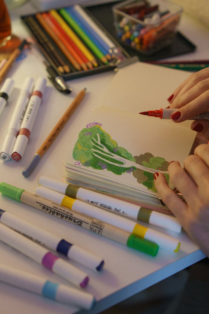 A person drawing with colorful markers and pencils, creating vibrant artwork.
